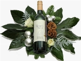 Fles witte wijn in kerstbloemstuk  burobloemen